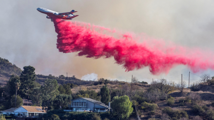 Aerial assault aims to stem LA Palisades fire eastward spread