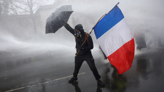 French police use tear gas and water cannons on protesters as nearly 1,000 arrested